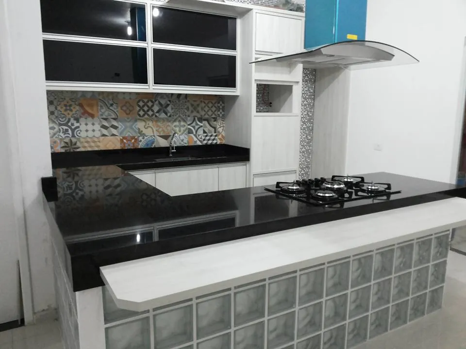 Cozinha com bancada de pedra escura e ilha
